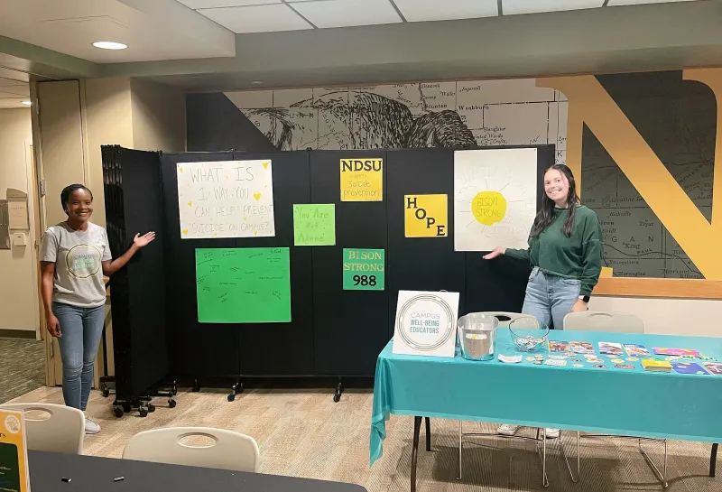 Students standing by Suicide Prevention display
