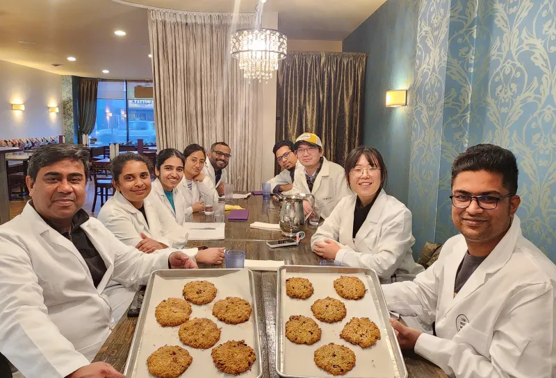 Dr. Shahidul Islam and his students posing with the cookies they made during Visit to Nichole's Bakery as a part of class