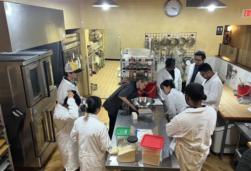 Students preparing cookies during Visit to Nichole's Bakery as a part of class