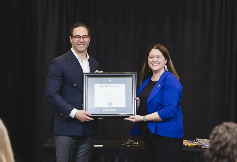 Dean Kathryn Birkeland presenting award to Honoree Brett Idderman