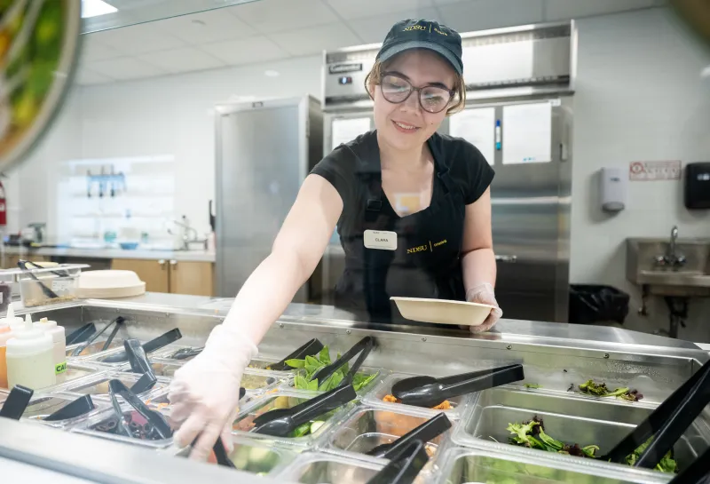 student working in the union market creating a grain bowl