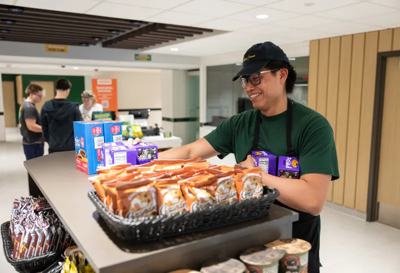 a student restocking food in the union market