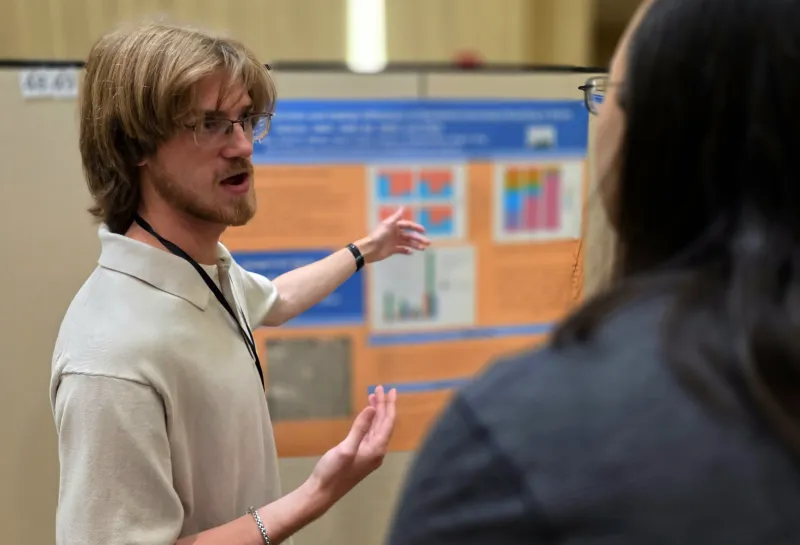 2026 summer REU students present their work at a poster session.