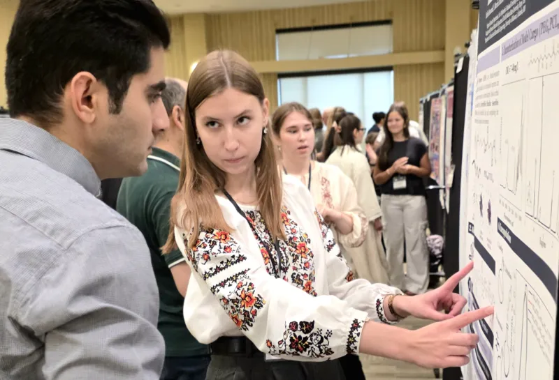 2026 summer REU students present their work at a poster session.