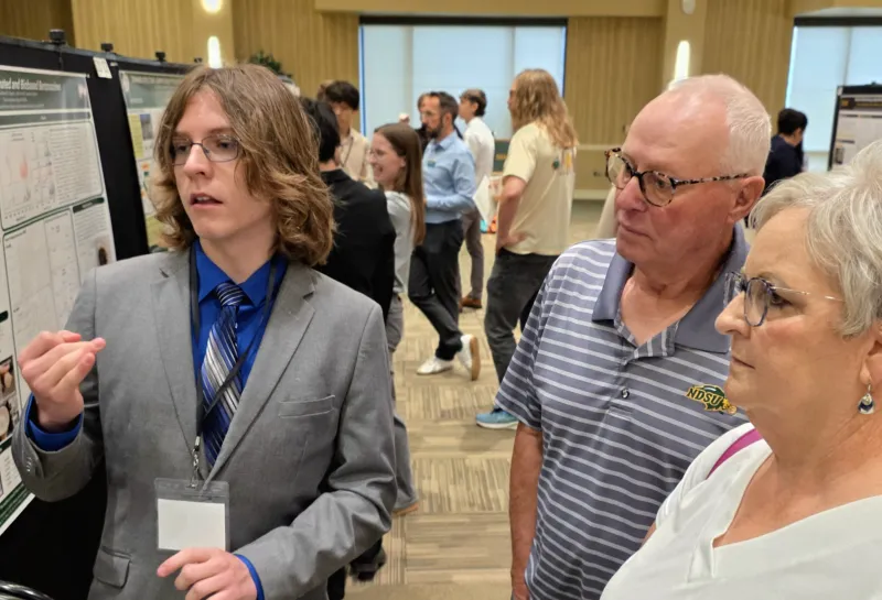 2026 summer REU students present their work at a poster session.