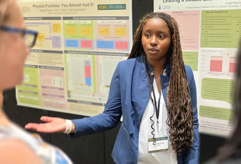 2026 summer REU students present their work at a poster session.
