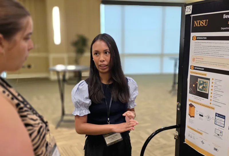 2026 summer REU students present their work at a poster session.