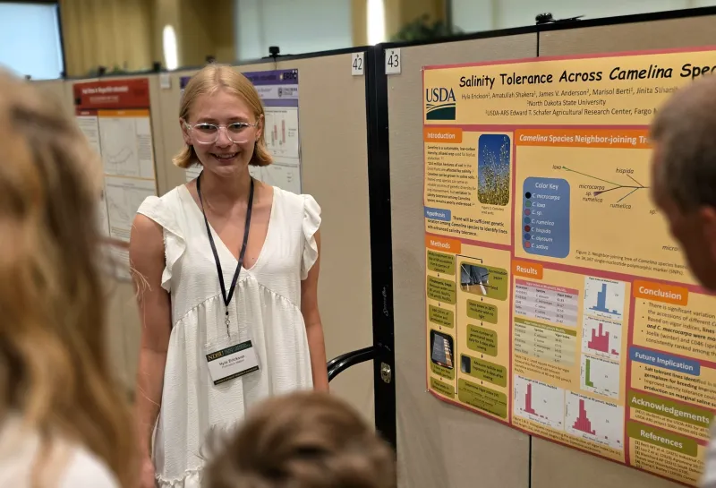 2026 summer REU students present their work at a poster session.