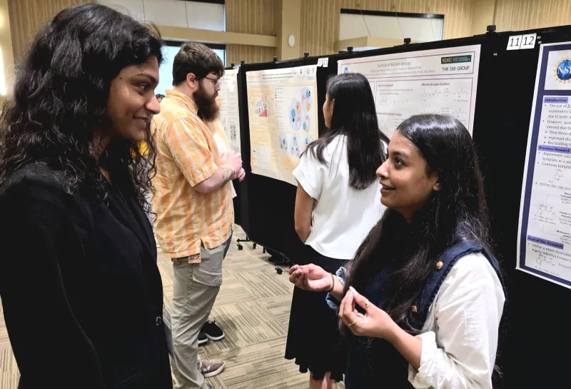 2026 summer REU students present their work at a poster session.