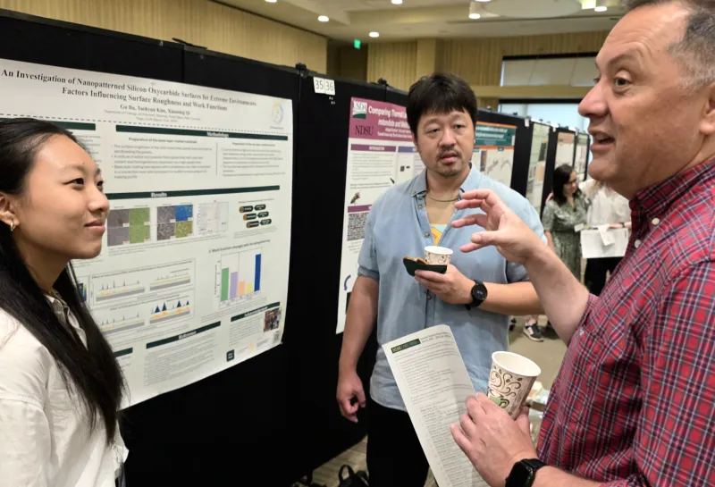 2026 summer REU students present their work at a poster session.