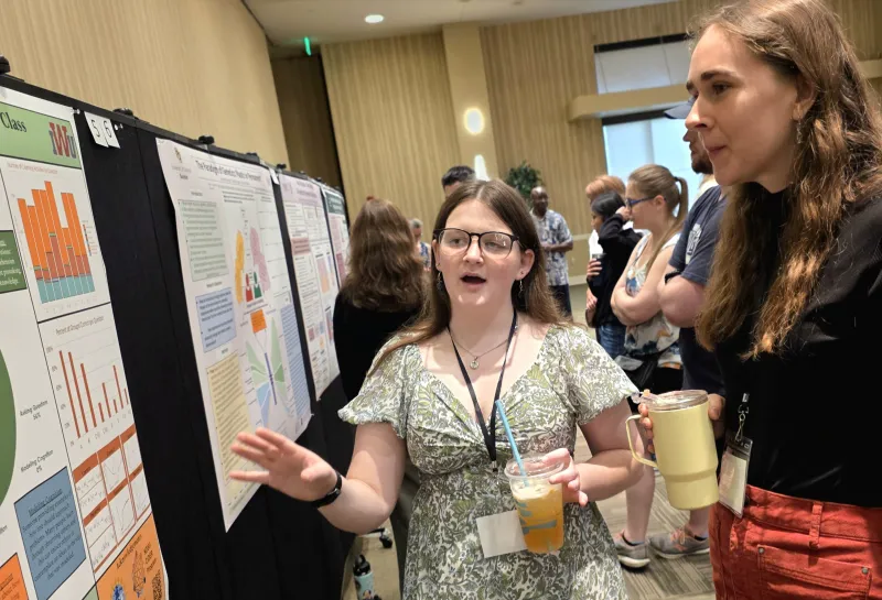 2026 summer REU students present their work at a poster session.