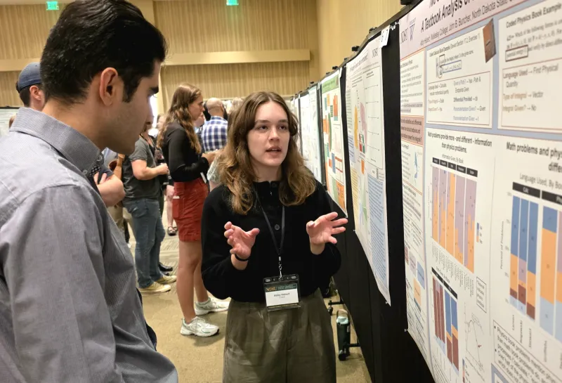 2026 summer REU students present their work at a poster session.