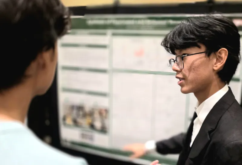 2026 summer REU students present their work at a poster session.