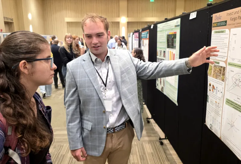 2026 summer REU students present their work at a poster session.