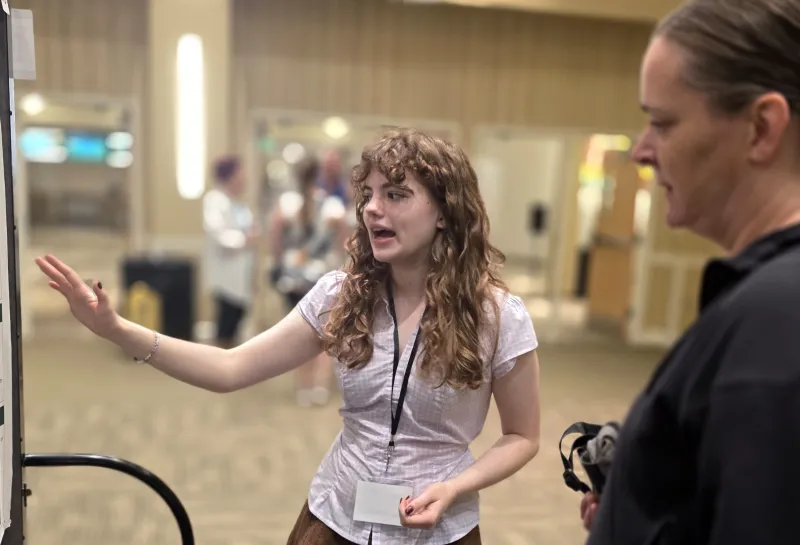 2026 summer REU students present their work at a poster session.