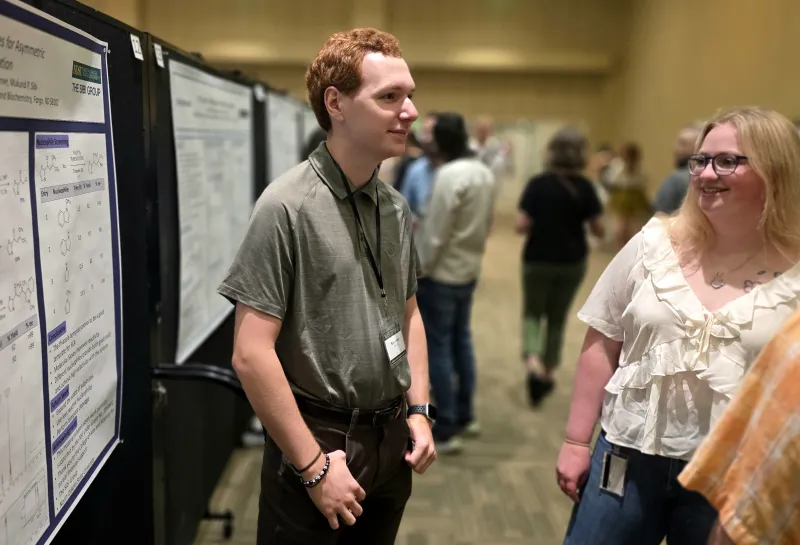 2026 summer REU students present their work at a poster session.