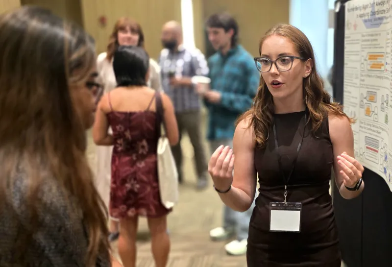 2026 summer REU students present their work at a poster session.