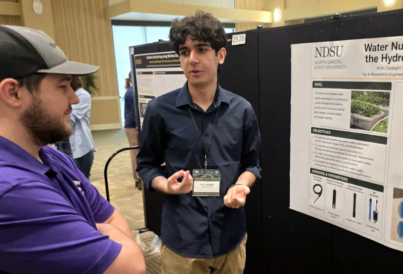 2026 summer REU students present their work at a poster session.