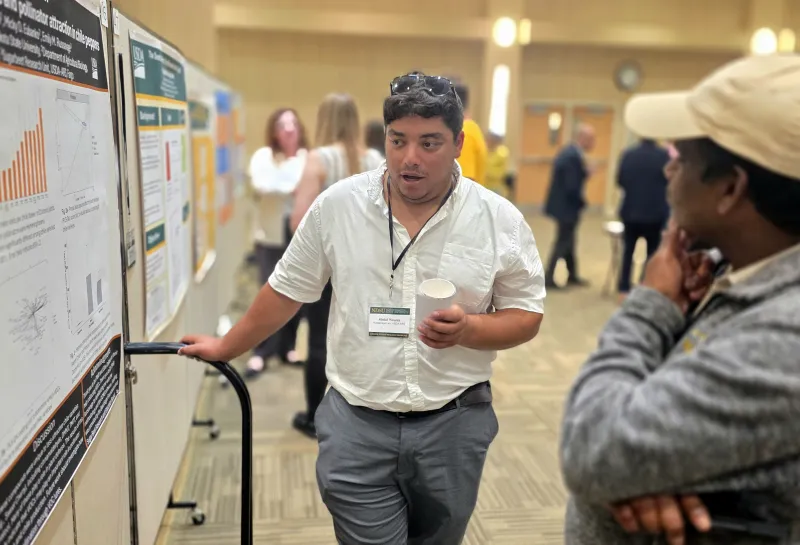 2026 summer REU students present their work at a poster session.