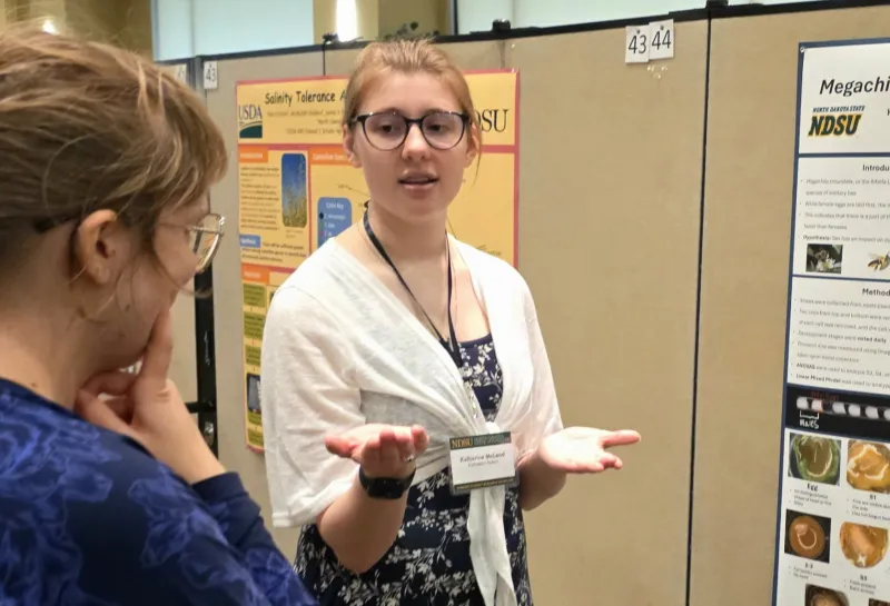 2026 summer REU students present their work at a poster session.