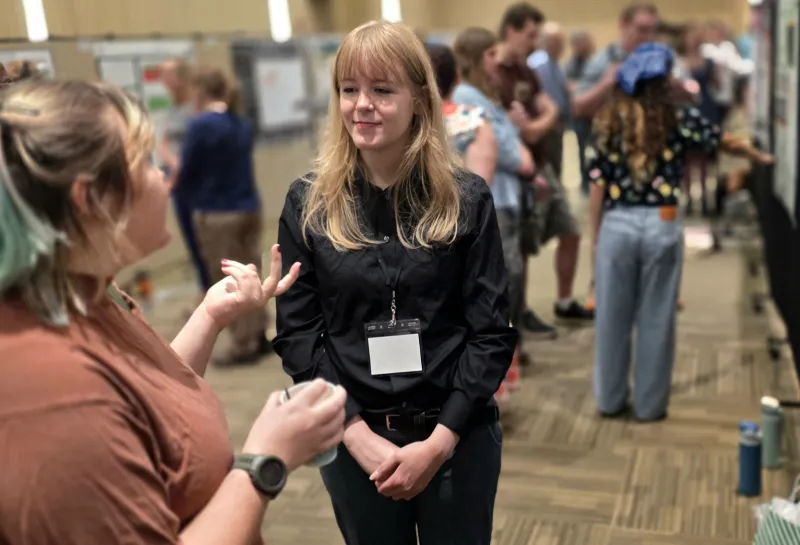 2026 summer REU students present their work at a poster session.