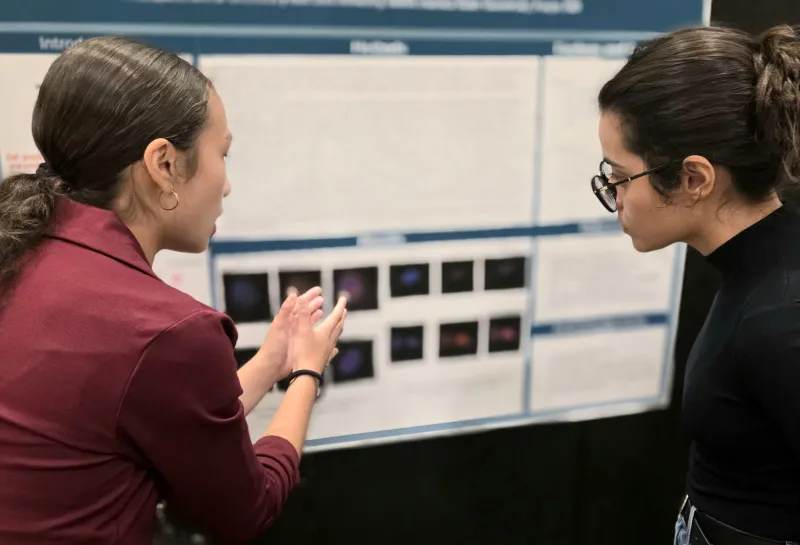 2026 summer REU students present their work at a poster session.