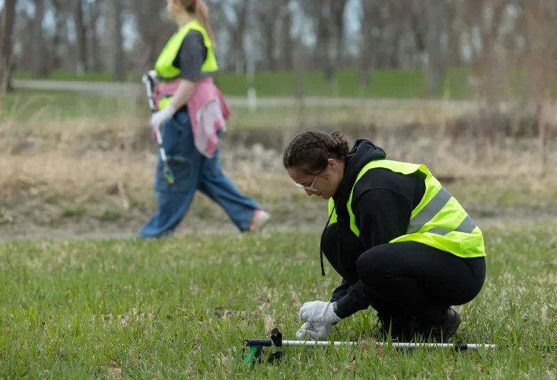 two volunteers picking up garbage in a park