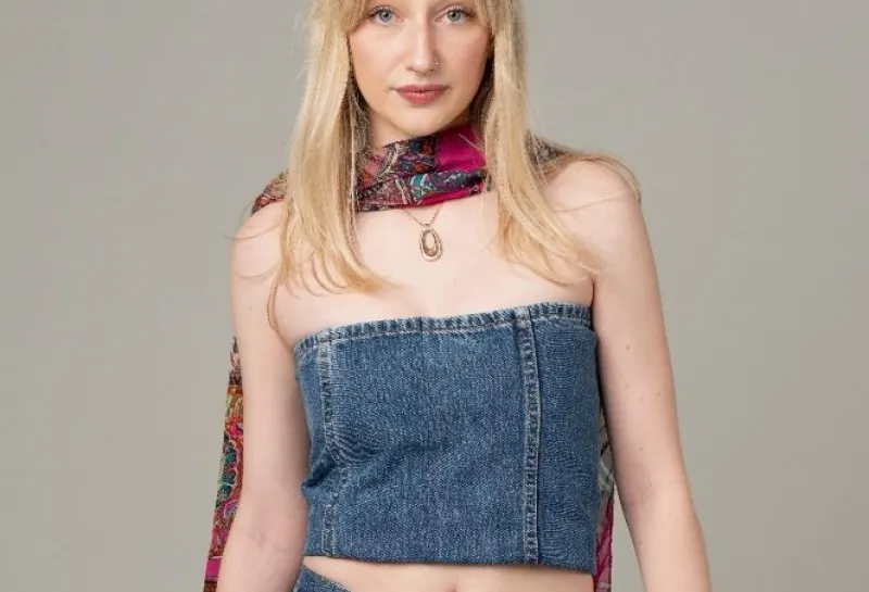 Student modeling a jean top and jean skirt.
