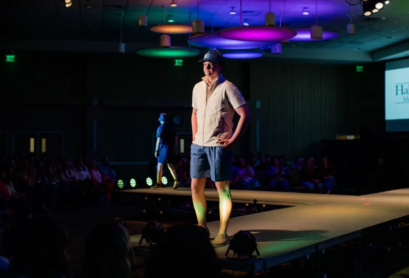 Model wearing a shorts and shirt while posing on runway.