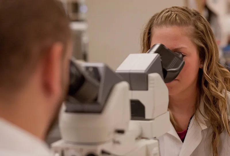 two student using microscopes