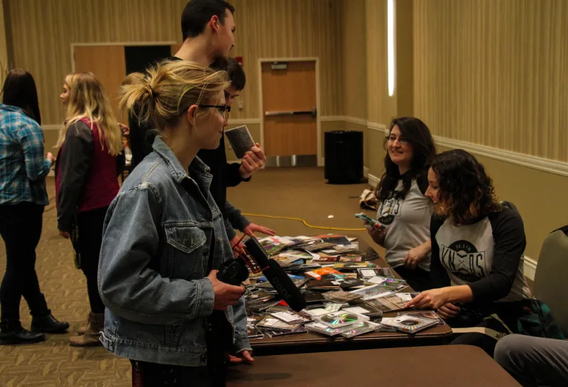 Students visiting at event table.