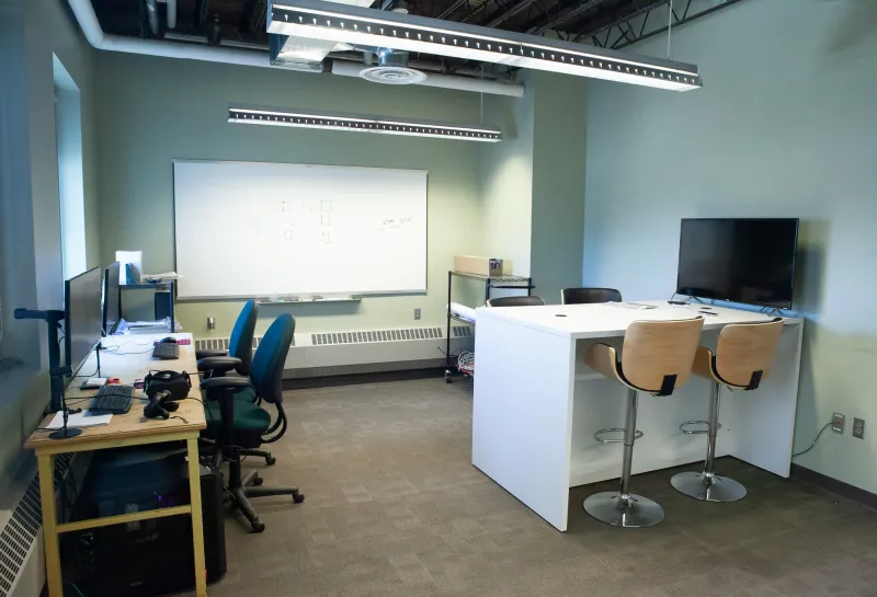 Classroom in Klai Hall with desks, chairs and computers.