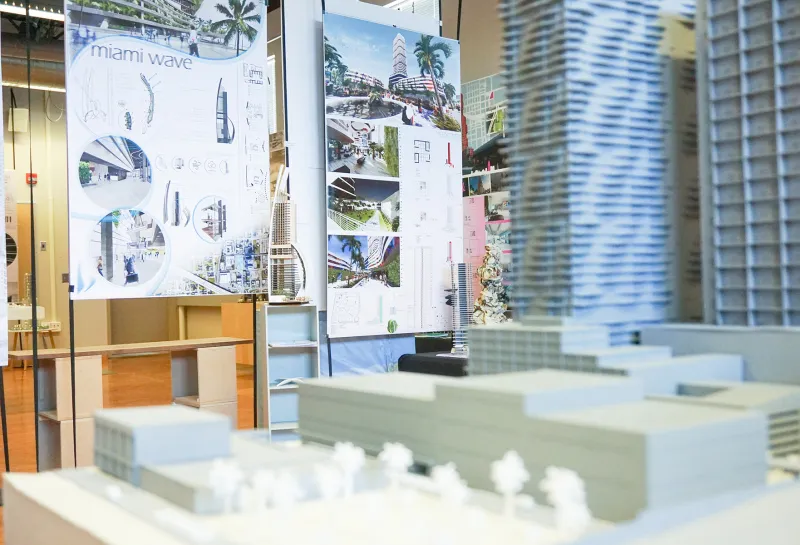 Model of building with art in the background located in the 5th Floor Gallery.