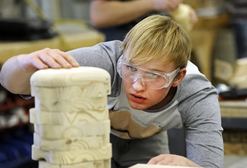 Student working with wood in woodshop.