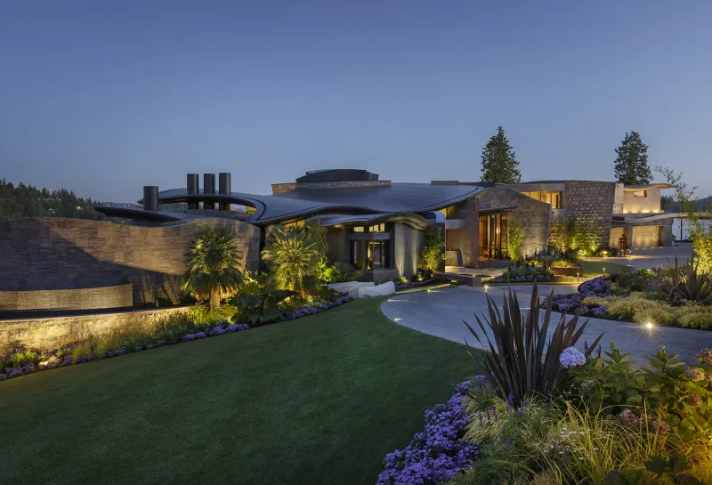 Exterior of large home with landsaping and lighting.