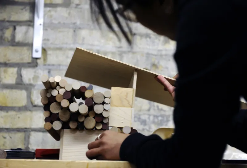 Student working with wood in woodshop.