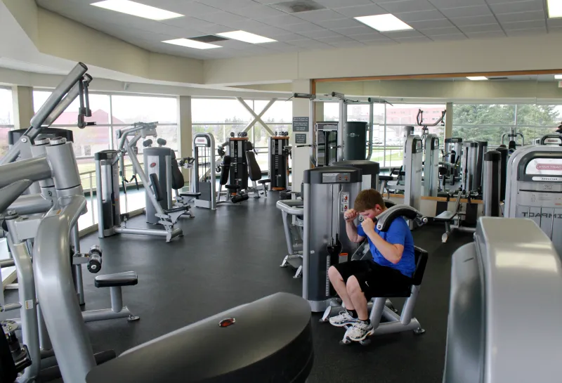 student using weight machine in exercise space