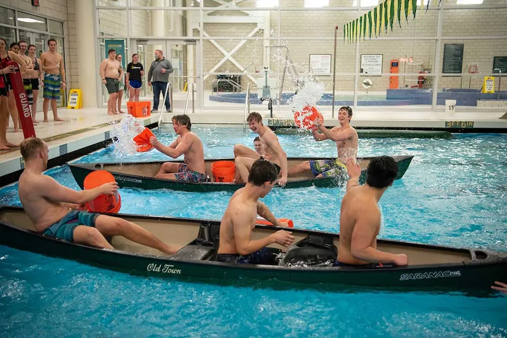 students trying to sink each other's canoe in a pool