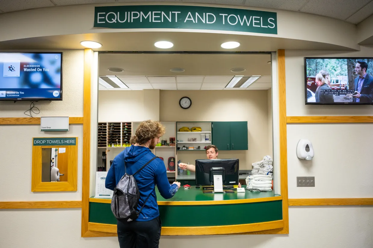 Student checking out equipment at recreation desk