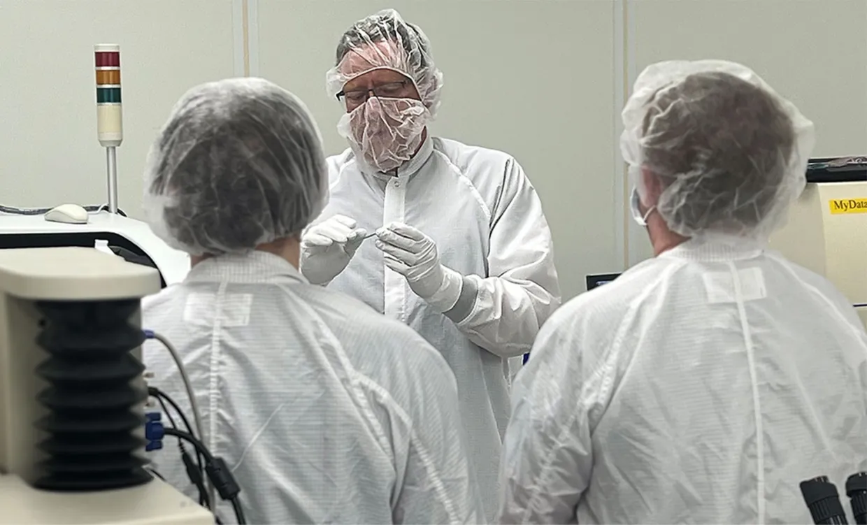 A researcher shows NDSU's clean room suite to a group of students