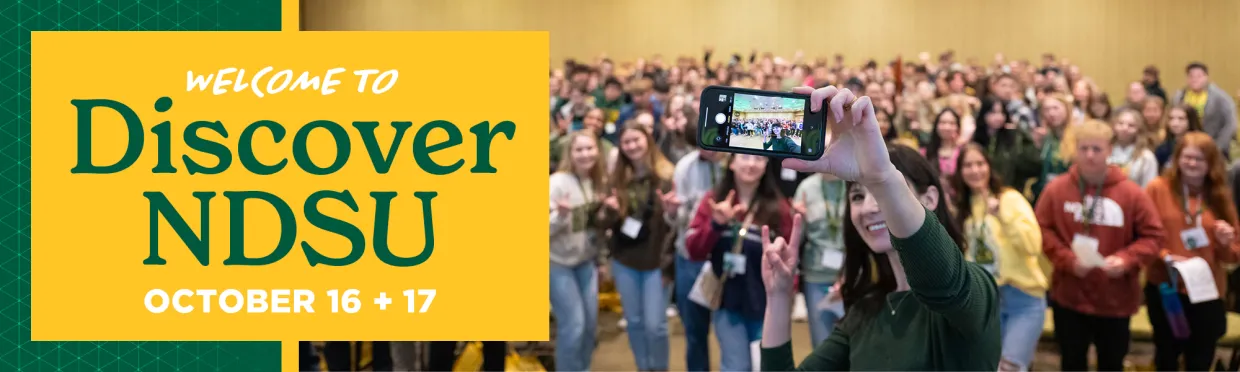 an NDSU staff member takes a selfie with a whole room of students attending Discover Day