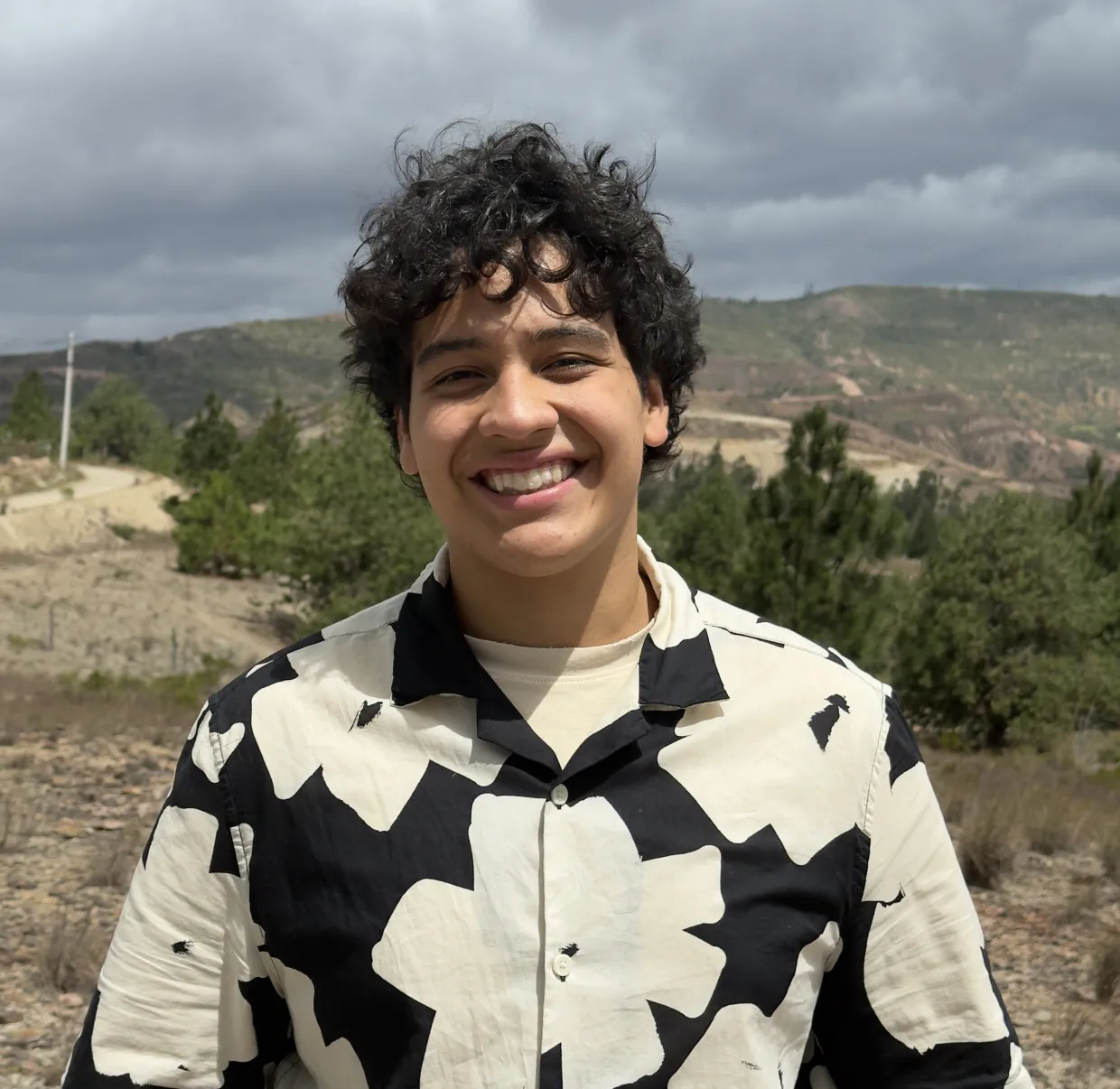 A phot of NDSU student Nicolas Pinto in front of a hill with trees in the background