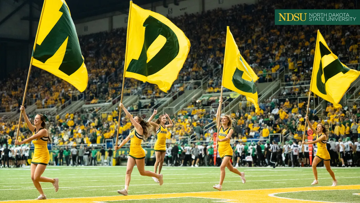cheerleaders with NDSU flags on football field