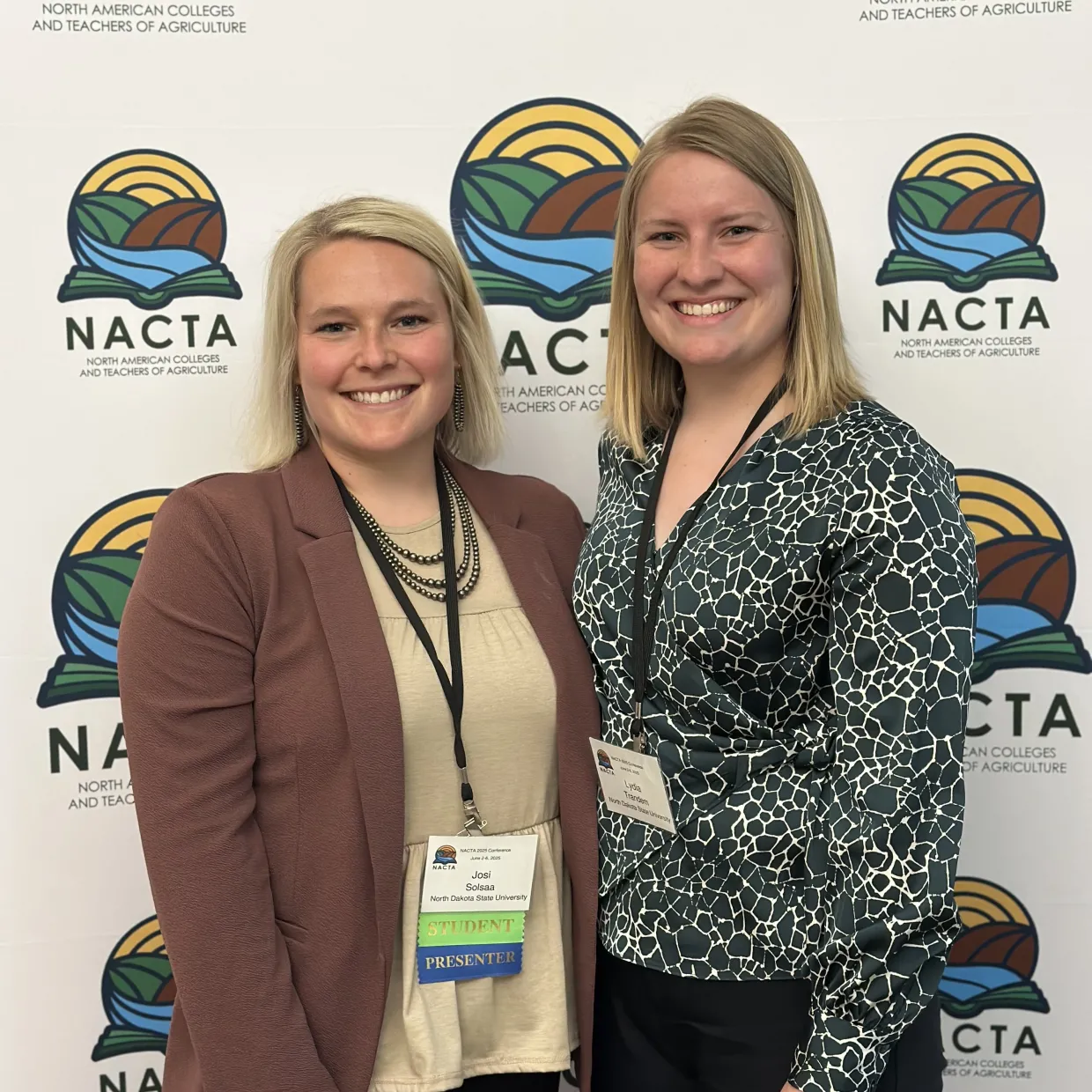 NDSU Faculty & Grad Student in front of NACTA banner