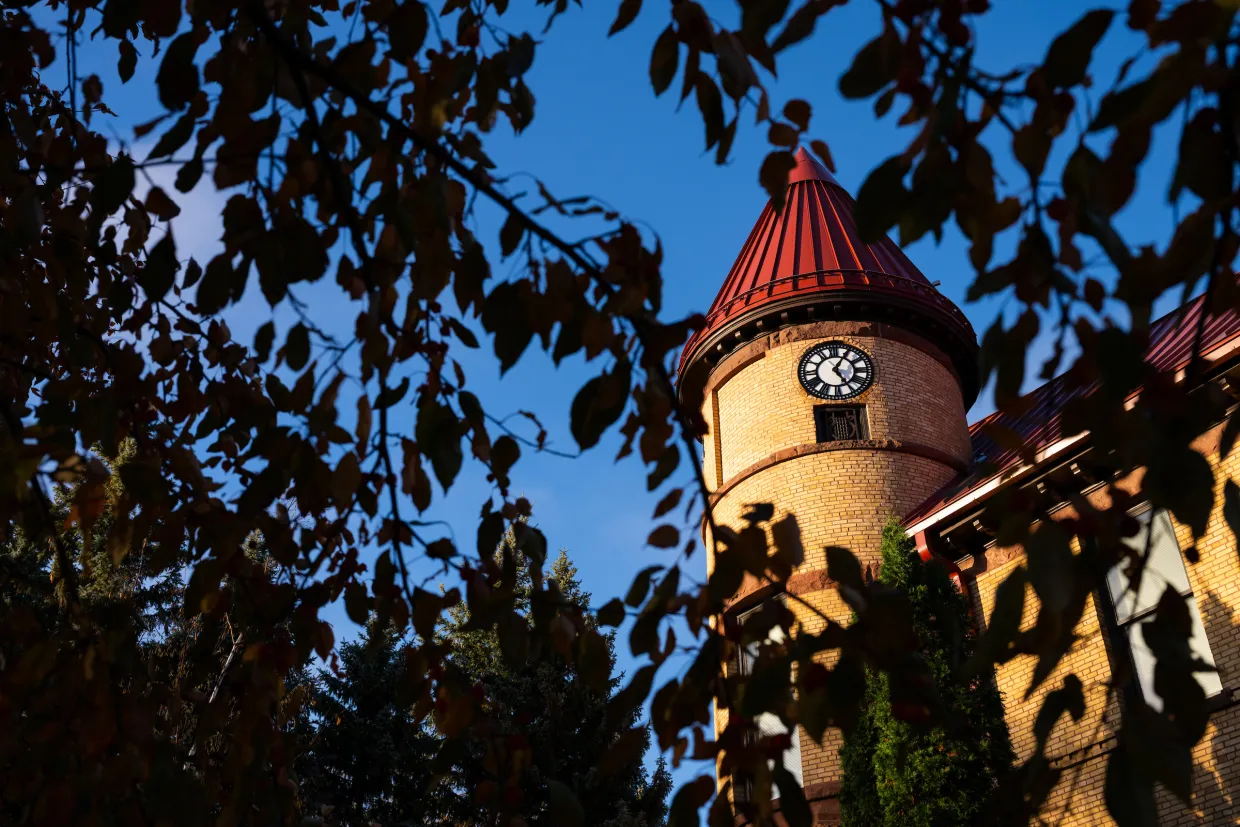 Old Main clock tower showing through the fall leaves