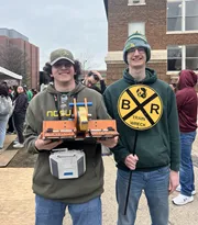 Students holding a robot