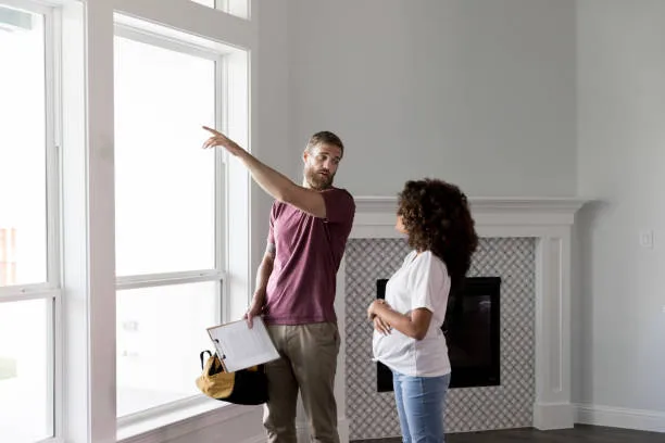 Home Inspector pointing to the window while talking to a homeowner