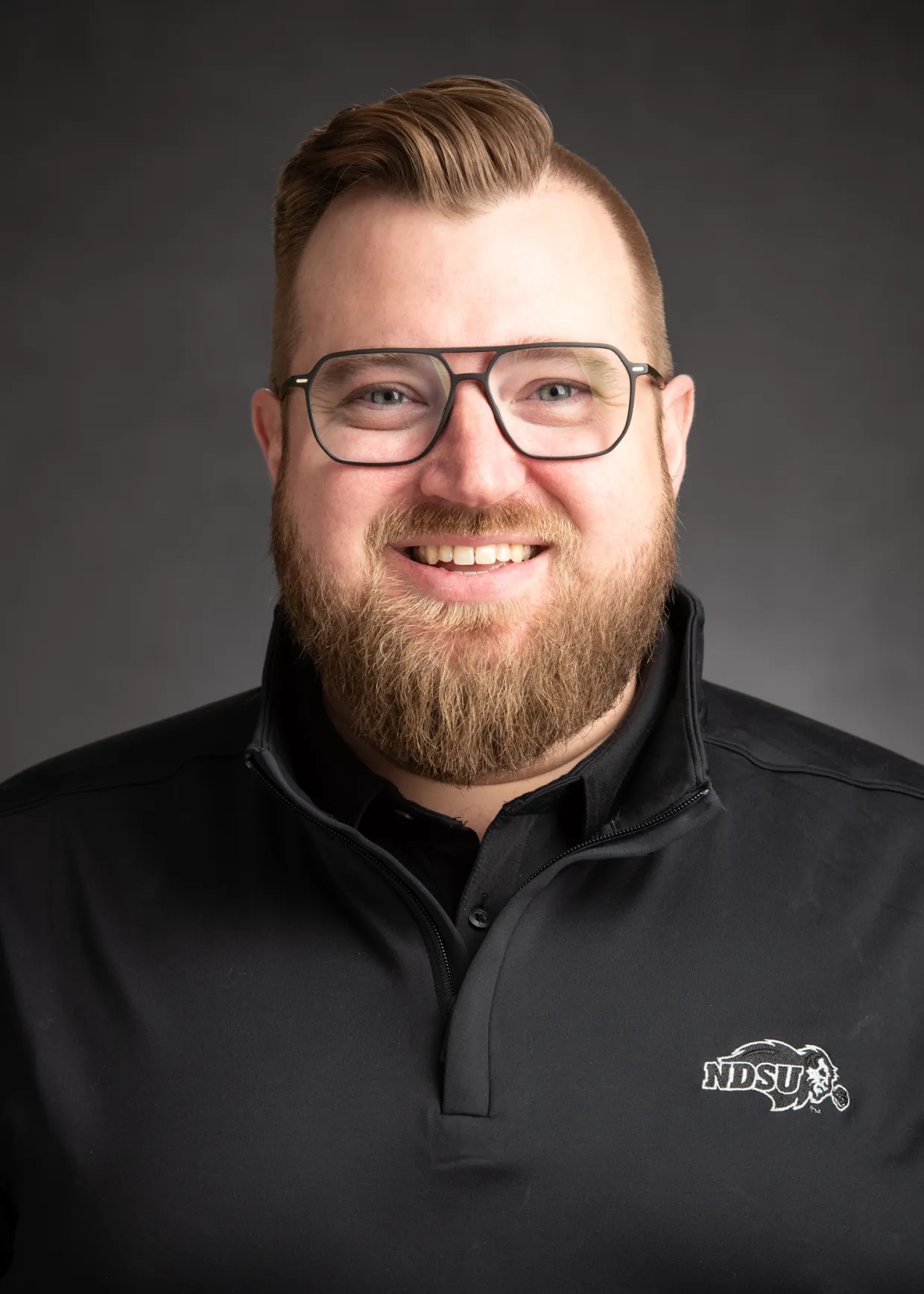 Headshot of Jordan Bonstrom in a black quarter-zip