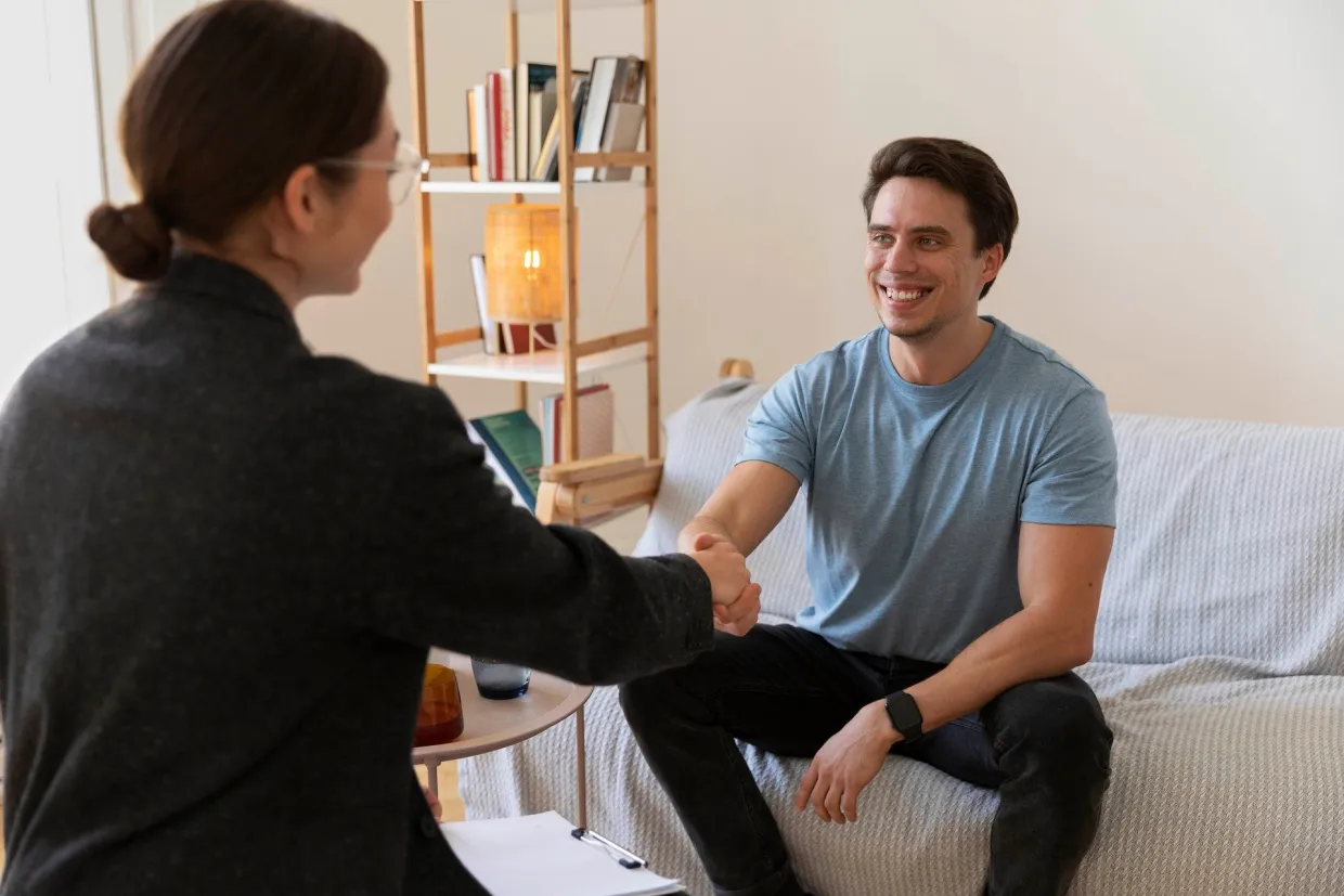 Woman shaking man's hand after therapy session