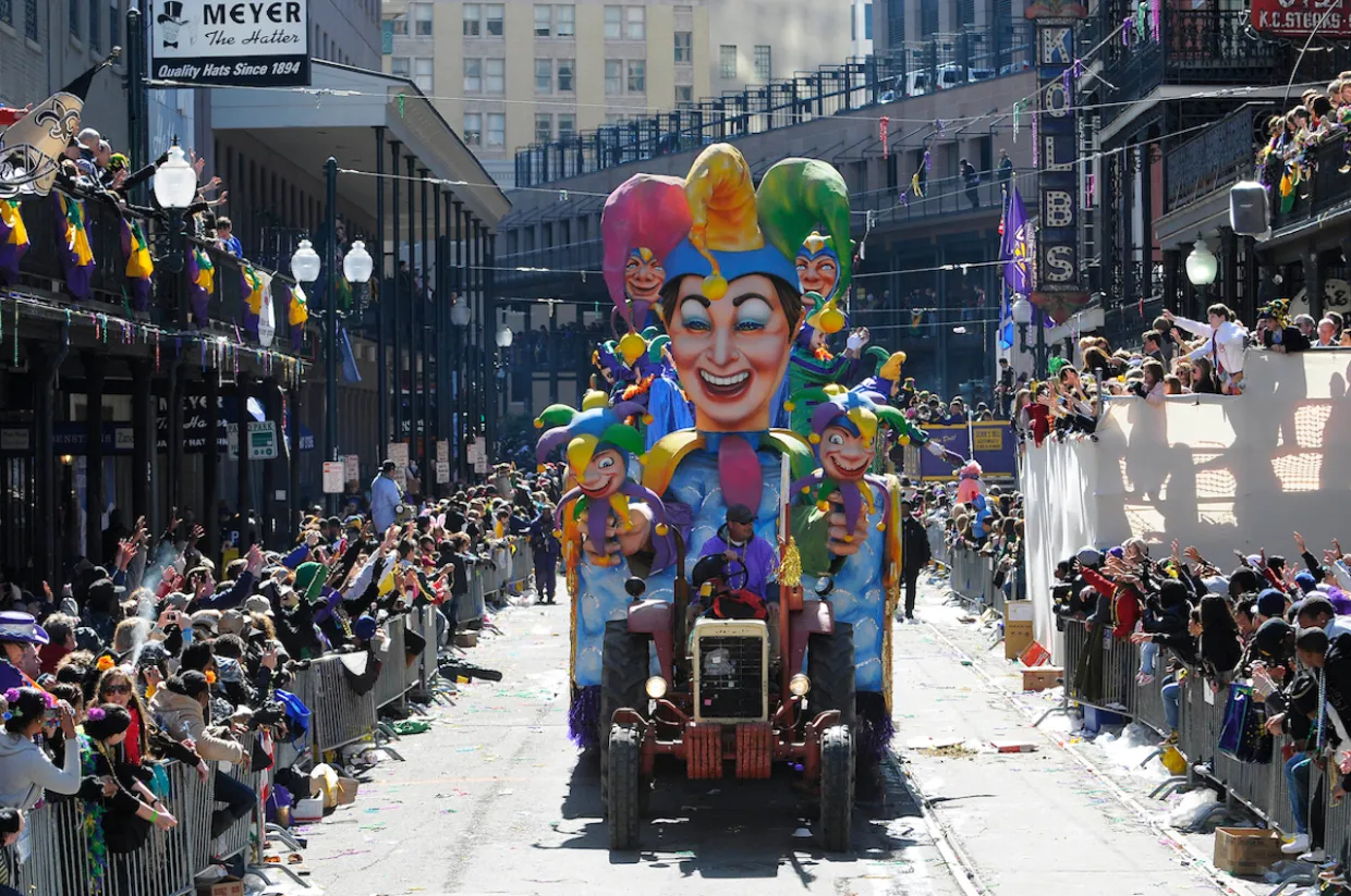 mardi gras parade with colorful jester float with crowds viewing the parade
